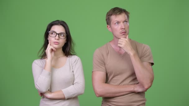 Casal jovem pensando juntos contra fundo verde — Vídeo de Stock