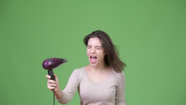 Jovem mulher bonita cantando com secador de cabelo — Vídeo de Stock