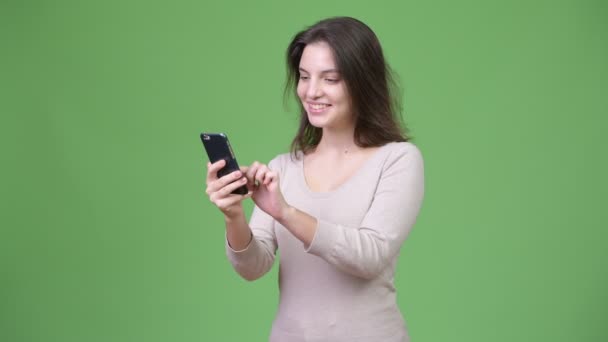 Jeune belle femme en utilisant le téléphone sur fond vert — Video