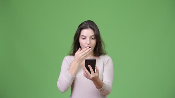 Молодая красивая женщина выглядит шокированной, когда пользуется телефоном — стоковое видео