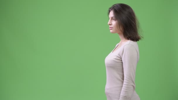 Visão de perfil de jovem bela mulher contra fundo verde — Vídeo de Stock