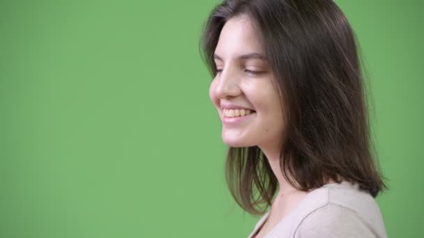 Profilo vista di giovane felice bella donna contro sfondo verde — Video Stock