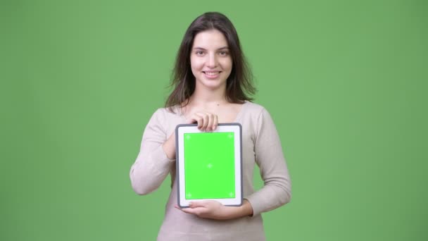 年轻快乐美丽的女人在显示数字平板电脑时微笑 — 图库视频影像