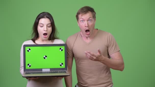 Νεαρό ζευγάρι εμφάνιση φορητού υπολογιστή ενώ αναζητούν σοκαρισμένος μαζί — Αρχείο Βίντεο