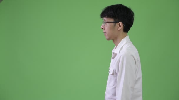 Fiatal ázsiai üzletember oldalnézetből. — Stock videók