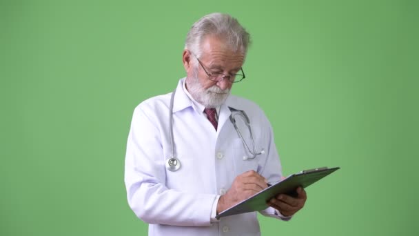 Beau médecin homme barbu senior sur fond vert — Video