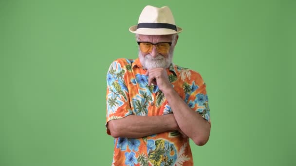 Красивий старший бородатий турист готовий до відпустки на зеленому тлі — стокове відео