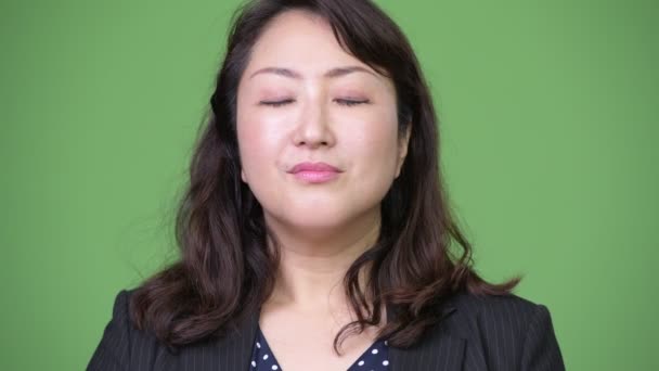 Mature beautiful Asian businesswoman relaxing with eyes closed — Stock Video