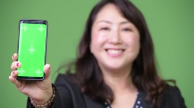 Olgun güzel Asya iş kadını gösteren telefon