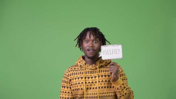 Joven hombre africano feliz gritando con selfie papel signo — Vídeos de Stock