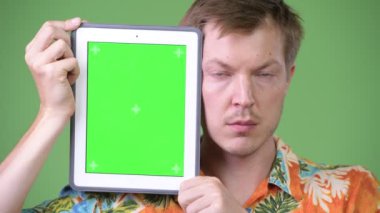 Genç yakışıklı turist adam gösteren dijital tablet