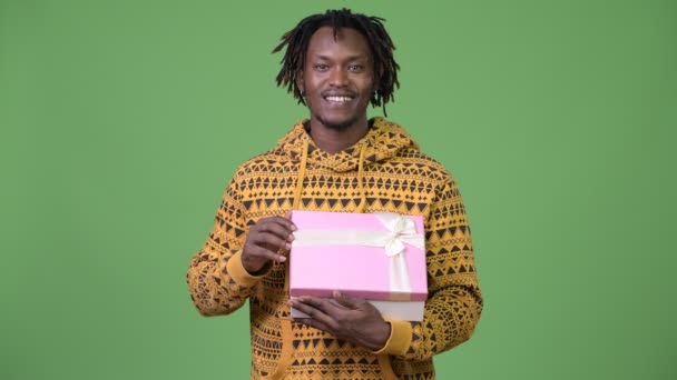 Joven hombre africano guapo abriendo caja de regalo y mirando sorprendido — Vídeo de stock