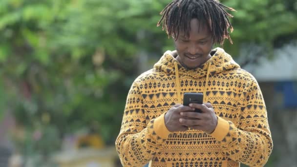 Junger gutaussehender afrikanischer Mann telefoniert auf der Straße — Stockvideo