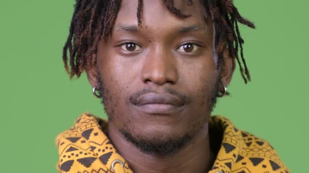 Молодой красивый африканский мужчина на зеленом фоне — стоковое видео