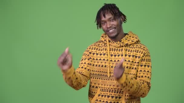 Joven hombre africano guapo chasqueando los dedos y mostrando algo — Vídeo de stock
