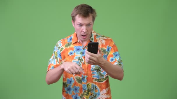 Joven turista guapo usando el teléfono y recibiendo malas noticias — Vídeo de stock