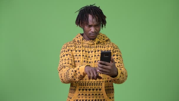 Joven hombre africano guapo usando el teléfono y recibiendo malas noticias — Vídeos de Stock