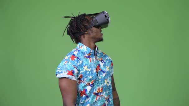 Молодой красивый африканский турист, использующий гарнитуру виртуальной реальности — стоковое видео