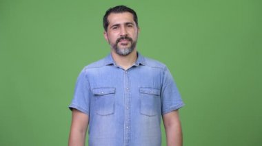 Farsça sakallı yakışıklı yeşil bir arka plana dayanır
