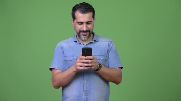 Schöner persischer bärtiger Mann mit Telefon und Denken — Stockvideo
