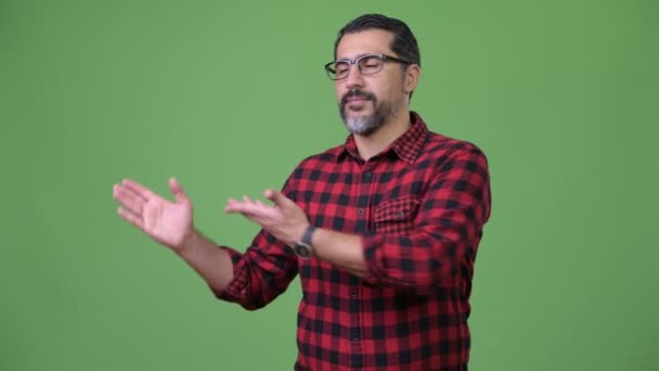 Yakışıklı Farsça sakallı adam bir şeyler gösteriyor — Stok video