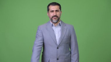 Yakışıklı Farsça sakallı işadamı kamera için işaret