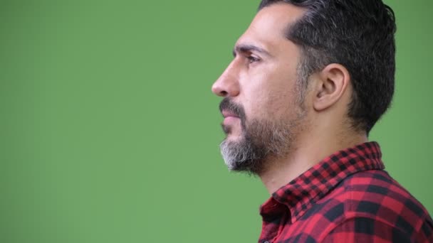 Vista del perfil del guapo hombre barbudo persa sonriendo — Vídeo de stock
