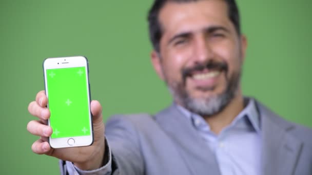Guapo persa barbudo hombre de negocios mostrando teléfono — Vídeos de Stock