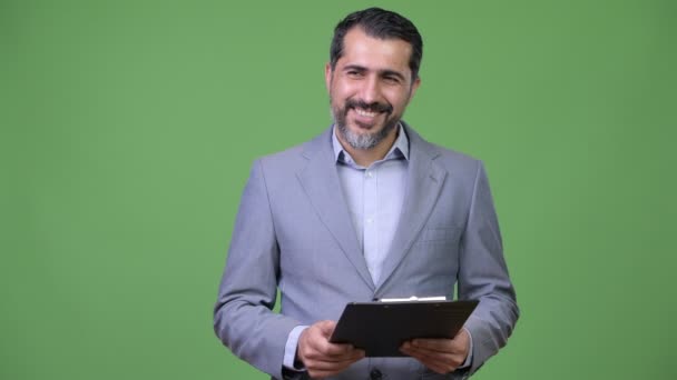 Красивый персидский бородатый бизнесмен режиссирует, держа планшет — стоковое видео