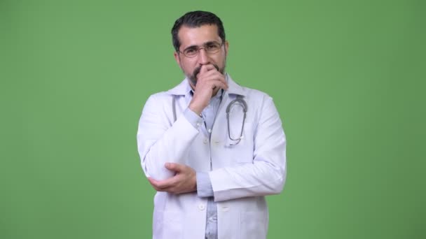 Knappe gelukkig Perzisch bebaarde man arts glimlachen terwijl denken — Stockvideo