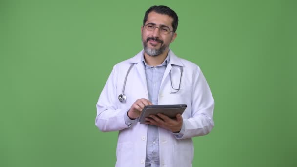 Όμορφος Περσικά γενειοφόρος άνδρας γιατρός σκέφτεται ενώ χρησιμοποιώντας ψηφιακή δισκίο — Αρχείο Βίντεο