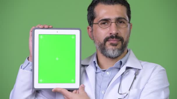 Bonito persa barbudo homem médico mostrando tablet digital — Vídeo de Stock