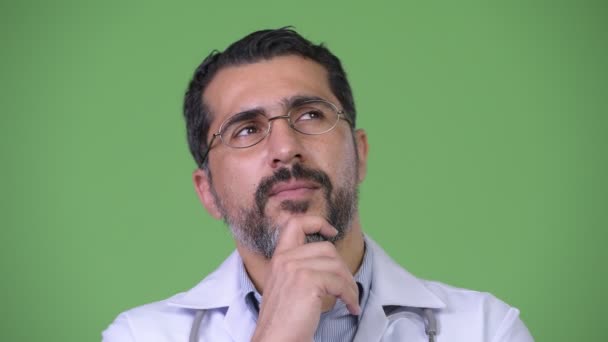 Красивый счастливый персидский бородатый доктор улыбается и думает: — стоковое видео