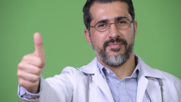 Красивый персидский бородатый мужчина доктор, показывающий большие пальцы — стоковое видео