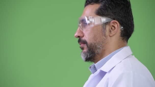 Profile view of handsome Persian bearded man doctor wearing protective glasses — Stock Video