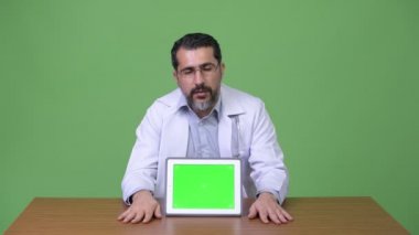 Yakışıklı Farsça dijital tablet gösterilen süre konuşan adam doktor sakallı