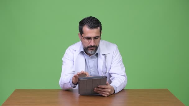 Farsça sakallı yakışıklı Doktor dijital tablet kullanırken düşünme — Stok video