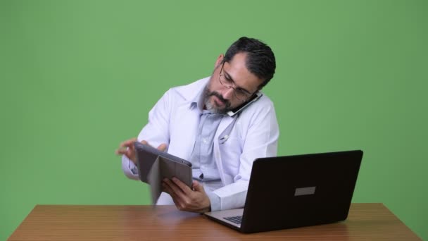Περσική όμορφος γενειοφόρος άνδρας γιατρός πολυδιεργασίας στο χώρο εργασίας — Αρχείο Βίντεο