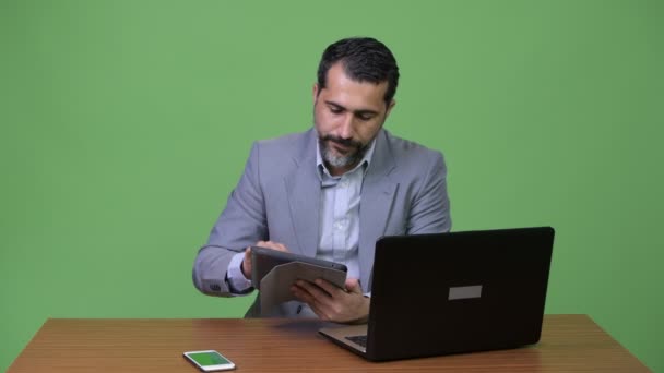 Estresado persa barbudo hombre de negocios multi-tarea en el trabajo y buscando ocupado — Vídeo de stock
