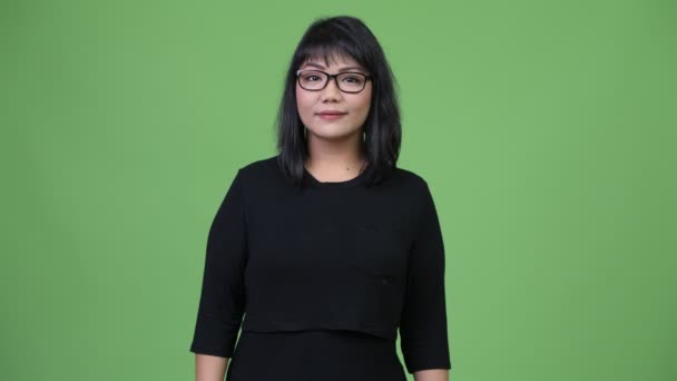 Schöne asiatische Geschäftsfrau vor grünem Hintergrund — Stockvideo