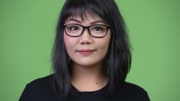 Beautiful Asian businesswoman against green background — Stock Video