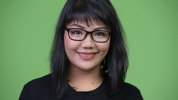 Beautiful happy Asian businesswoman smiling against green background — Stock Video