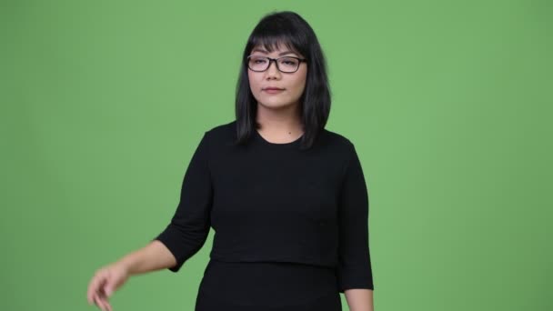 Красивая азиатская бизнесвумен думает, указывая пальцем вверх — стоковое видео