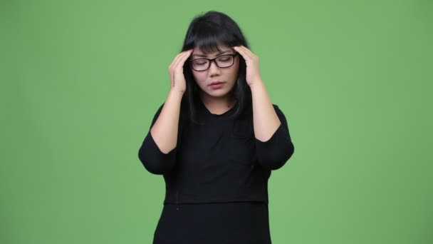 У прекрасной азиатской бизнесвумен болит голова — стоковое видео