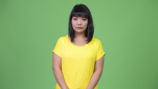 Mooie Aziatische vrouw tegen groene achtergrond — Stockvideo