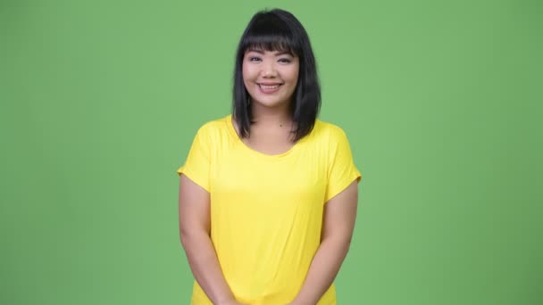 Ομορφη ευτυχισμένη γυναίκα της Ασίας χαμογελώντας πράσινο φόντο — Αρχείο Βίντεο