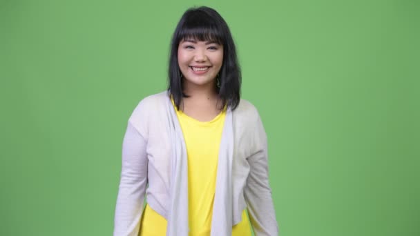 Hermosa mujer asiática feliz sonriendo sobre fondo verde — Vídeos de Stock