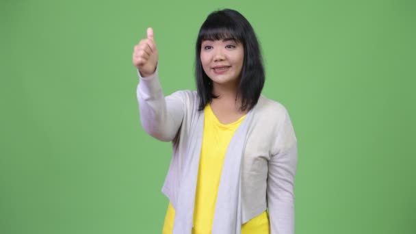 Beautiful happy Asian woman smiling while giving thumbs up — Stock Video