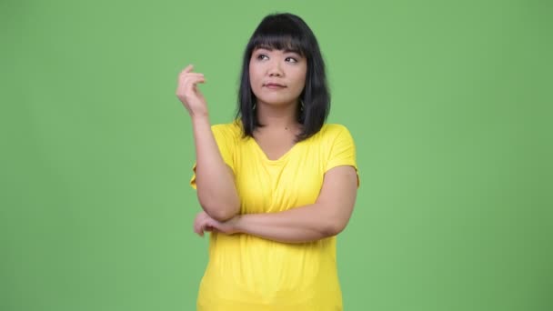 Vacker asiatisk kvinna ler och tänker — Stockvideo