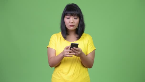 Piękna kobieta azjatyckich myślenia przy użyciu telefonu — Wideo stockowe